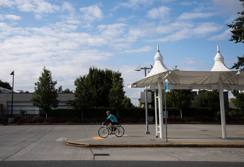 Ben Watanabe rides away from the Smokey Point Transit Center on Saturday toward 172nd Street NE/Highway 531 in Arlington. (Olivia Vanni / The Herald)