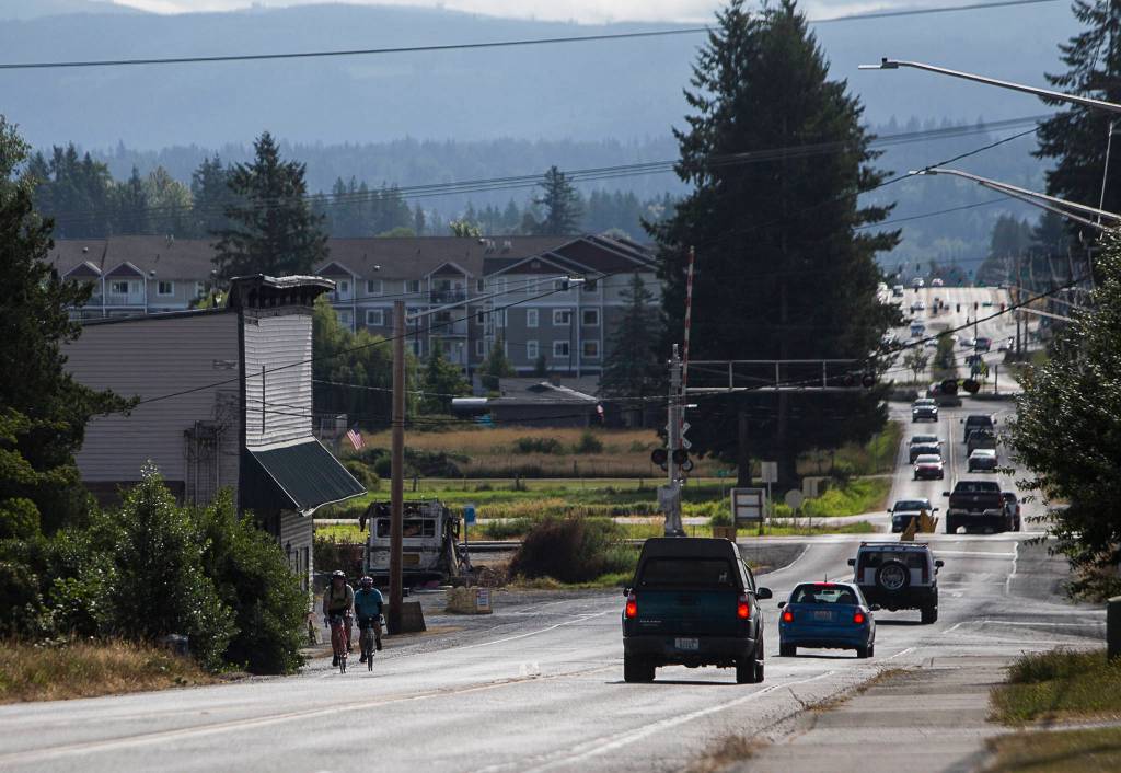 Ben Watanabe and Zachariah Bryan ride west along Highway 531 on Saturday near Arlington. (Olivia Vanni / The Herald)