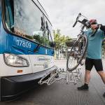 Street Smarts columnist Ben Watanabe places his bike onto the Community Transit 201 bus rack on Saturday, July 17, 2021 in Everett, Wash. (Olivia Vanni / The Herald)