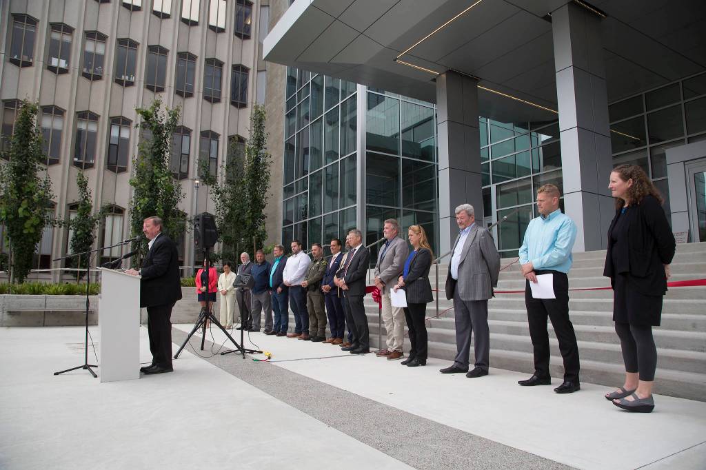 Backed by Snohomish County leaders and representatives from labor, construction companies and others, Snohomish County Executive Dave Somers speaks at a ribbon-cutting ceremony marking the completion of the Snohomish County Courthouse remodel Thursday in Everett. (Andy Bronson / The Herald)