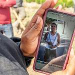A worker looks at a photo of Sebastian Francisco Perez, an Oregon farmworker who died while working during the Pacific Northwests extreme heat wave at the end of June. (AP Photo/Nathan Howard, file)