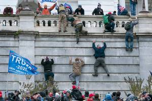 FILE - In this Jan. 6, 2021, file photo, violent insurrectionists loyal to President Donald Trump scale the west wall of the the U.S. Capitol in Washington. Two Seattle police officers who were in Washington, D.C., during the January 6 insurrection were illegally trespassing on Capitol grounds while rioters stormed the building, but lied about their actions, a police watchdog said in a report released Thursday, July 8, 2021. (AP Photo/Jose Luis Magana, File)