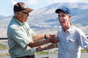 Gov. Jay Inslee, left, attaches a "Washingtonian" pin to and Bill Nye's shirt during a visit to Johnston Ridge Observatory Thursday, July 8, 2021 at Mount St. Helens in Toutle, Wash.(Courtney Talak/The Daily News via AP)