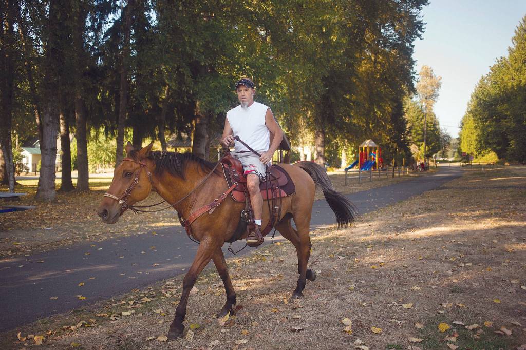 Chuck Denny heads out on his quarter horse, Kona, from the Machias Trailhead. (Andy Bronson / The Herald)