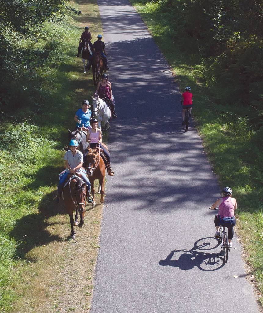 Horse riders and cyclists share the trail near Hilltop Road between Arlington and Marysville. (Andy Bronson / The Herald)