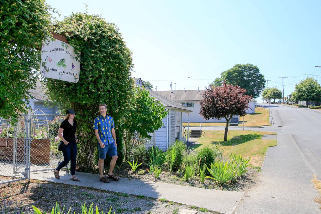 Alyssa Gray and Ryan Weber, Delta neighborhood residents, exit a community garden on the site proposed for high-density housing. (Kevin Clark / The Herald)