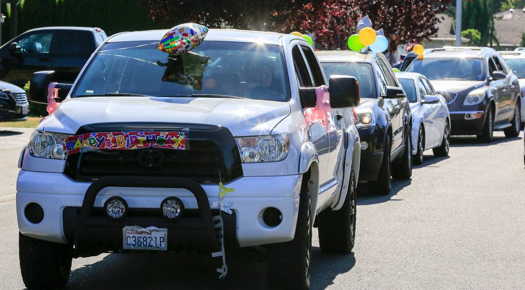 Cars line up to give Essie Klopfenstine drive-by birthday wishes and presents Tuesday afternoon in Marysville. (Kevin Clark / The Herald)