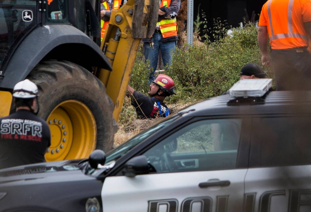 An Everett firefighter stands in a hole at the scene of a possible tunnel collapse along I-5 at Pacific Avenue on Thursday. (Olivia Vanni / The Herald)