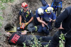 DOUG RAMSAY / For the Herald
Using a remote camera mounted on a long pole, technical rescue crews from the Everett and Seattle fire departments look at the monitor as they search inside a tunnel that was dug under the north-bound I-5 off ramp to Pacific Avenue on Thursday, after crews using a backhoe had dug farther back into the tunnel. 20210715
