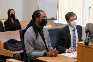 NFL football player Richard Sherman, center, sits at a hearing at King County District Court with his attorney Cooper Offenbecher, right, as his wife Ashley Sherman looks on, Friday, July 16, 2021, in Seattle. Prosecutors in Washington state have charged Sherman, who has played for the Seattle Seahawks and the San Francisco 49ers, after police said he drunkenly crashed his SUV in a construction zone and tried to break into his in-laws' home. (AP Photo/Ted S. Warren)