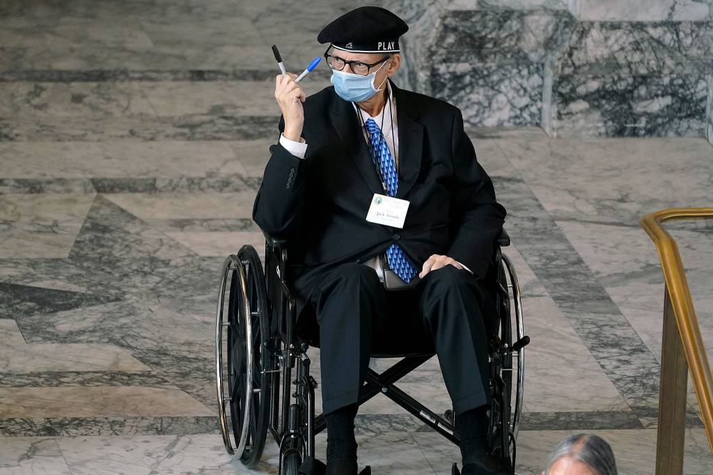 Democrat Jack Arends, a member of Washingtons Electoral College, holds up the markers he used to cast his votes for the president and vice president of the United States at the state Capitol in Olympia, Wash., Monday, Dec. 14, 2020, as he waits to take part in a group photo. (AP Photo/Ted S. Warren)