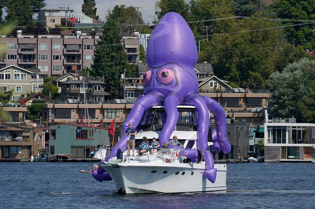 A boat festooned with an inflatable octopus cruises on Lake Union near the park where the Seattle Kraken NHL hockey team was holding its expansion draft event. (Ted S. Warren / Associated Press)