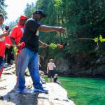 Marvin Shelby tosses a rose into the Skykomish River at Eagle Falls in memory of his son, Devin Shelby. (Kevin Clark / The Herald)