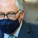 Washington Gov. Jay Inslee looks down at a stack of bills to be signed into law, Wednesday, May 12, 2021, at the Capitol in Olympia, Wash. The measures included a bill that prohibits openly carrying guns and other weapons at the state Capitol and protests statewide. (AP Photo/Ted S. Warren)