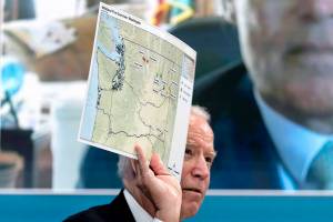 President Joe Biden holds up a map of wildfires in Washington state as he speaks with governors about ongoing efforts to strengthen wildfire prevention, preparedness and response efforts, and hear firsthand about the ongoing impacts of the 2021 wildfire season in the South Court Auditorium in the Eisenhower Executive Office Building on the White House Campus in Washington, Friday, July 30, 2021. (AP Photo/Andrew Harnik)
