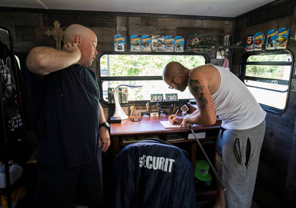 Benjamin Stum and brother, Joshua Standridge, write down measurements while they work on Stums trailer in Marysville. (Olivia Vanni / The Herald)