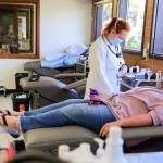 Phlebotomist Heather Evans preps JaNeen Aagaard for a donation at Bloodworks Northwest on Friday in Everett. (Kevin Clark / The Herald)