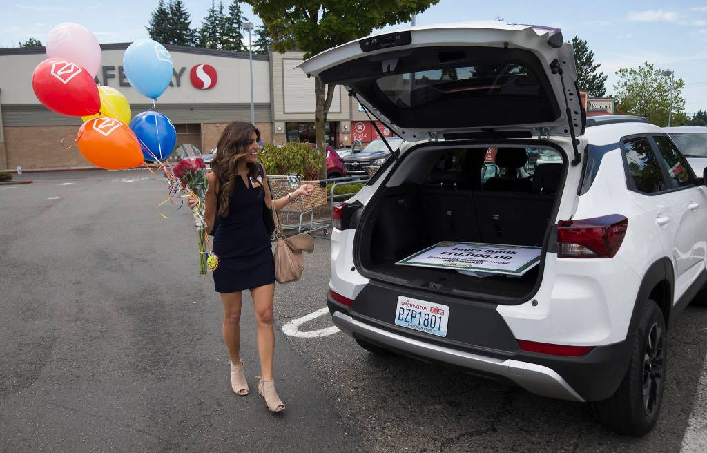 Before every delivery, Danielle Lam with the Prize Patrol from Publishers Clearing House fills balloons and gets flowers for the winner. (Andy Bronson / The Herald)