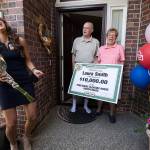 Laura Smith, with husband Tom, makes Danielle Lam laugh after being presented with a check for $10,000 from The Prize Patrol from Publishers Clearing House on Wednesday, July 28, 2021 in Mukilteo, Washington. (Andy Bronson / The Herald)