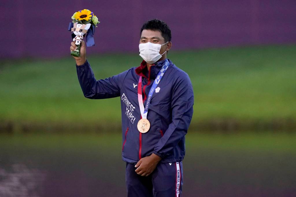 Bronze medal winner C.T. Pan, of Taiwan, stands on the podium after the men's golf event at the 2020 Summer Olympics, Sunday, Aug. 1, 2021, at the Kasumigaseki Country Club in Kawagoe, Japan, (AP Photo/Matt York)