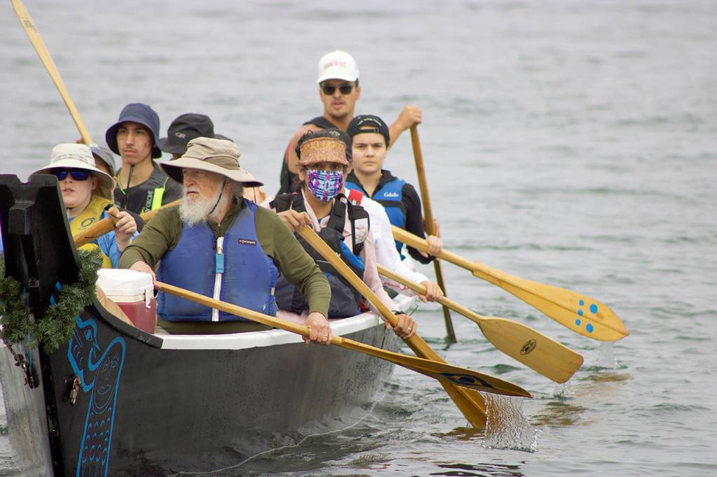 Blue Heron Canoe Family paddlers back away from the shore in front of the Edmonds Waterfront Center, beginning their two week journey to Lummi Island. (Isabella Breda / The Herald)