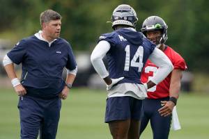 Seattle Seahawks quarterback Russell Wilson, right, talks with wide receiver DK Metcalf (14) as offensive coordinator Shane Waldron looks on at left, during NFL football practice Saturday, July 31, 2021, in Renton, Wash. (AP Photo/Ted S. Warren)