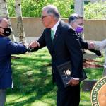 From left, state health Secretary Umair Shah, Gov. Jay Inslee, King County Executive Dow Constantine and Susan Mullaney, Kaiser Permanente regional president for Washington state, say goodbye to each other after a news conference where Inslee announced a COVID-19 vaccine mandate for Washington state employees and health-care workers on Monday in Seattle. (Ken Lambert/The Seattle Times via AP)