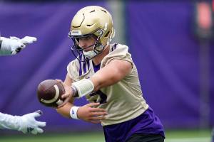 Washington Huskies quarterback Dylan Morris hands-off the ball during an NCAA college football team practice Friday, Aug. 6, 2021, in Seattle. (AP Photo/Elaine Thompson)