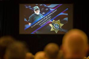 An image of Clark County Sheriff's Detective Jeremy Brown, who was shot to death July 23 while on duty, is projected on a screen during a celebration of his life at ilani Casino in La Center, Wash., Tuesday, Aug. 3, 2021. More than 2,500 people attended the standing room-only service to honor Brown, 46, who was promoted to honorary sergeant after his death. (Amanda Cowan/The Columbian via AP)
