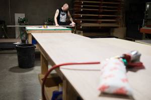 An employee sands down a board inside Ironwood Manufacturing's new Arlington location on Friday, Aug. 13, 2021. (Olivia Vanni / The Herald)
