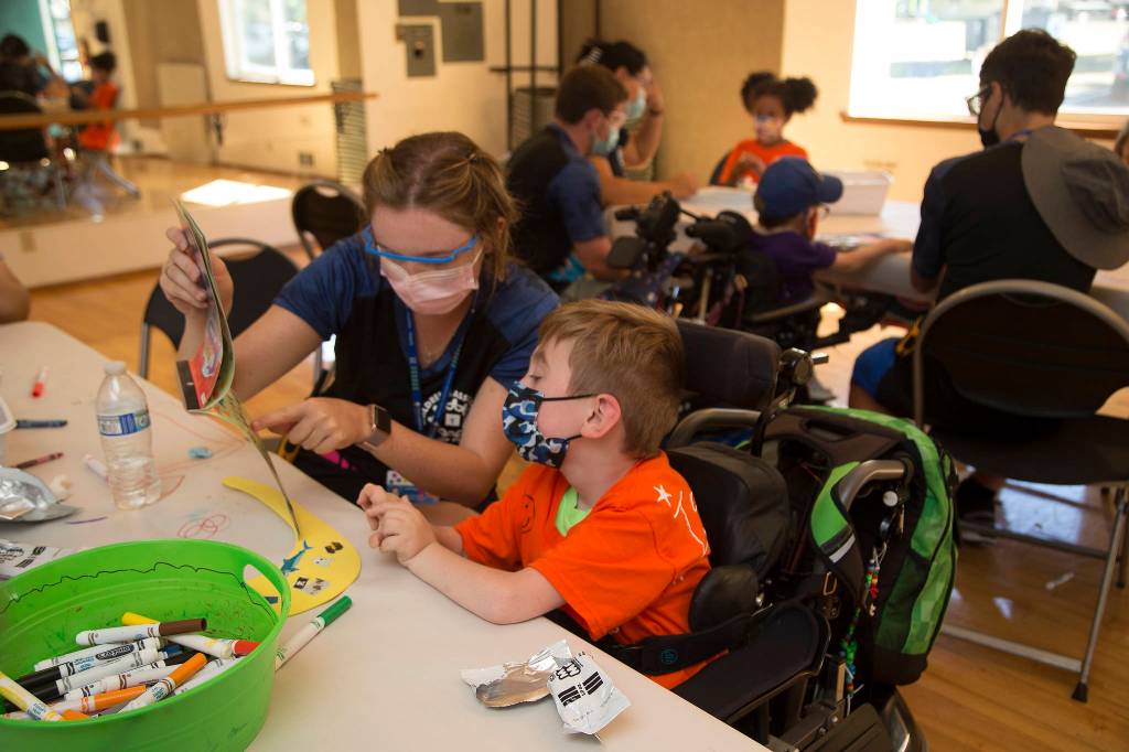 Lainey Nations helps Isaiah Kobernik pick out stickers during craft time of Camp Prov, a week-long camp for kids with special needs. (Andy Bronson / The Herald)