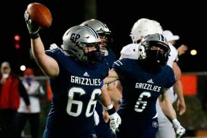 Glacier Peak's Adam Troxel celebrates a fumble recovery with teammate Jackson Hawkins at Veterans Memorial Stadium Friday night in Snohomish on March 12, 2021. (Kevin Clark / The Herald)