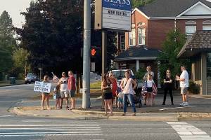 Those at risk of losing their job for not taking the COVID-19 vaccine, and their supporters, lined an intersection to protest vaccine mandates in downtown Snohomish Thursday evening. (Isabella Breda / The Herald)