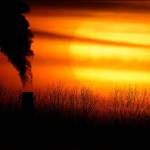 Emissions from a coal-fired power plant are silhouetted against the setting sun in Independence, Mo., in February. (Charlie Riedel / Associated Press file photo)