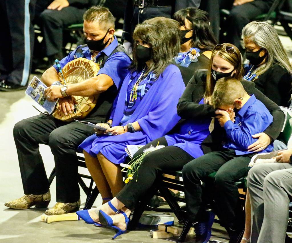 Family members, including Alan and Paula Cortez (left), attend the memorial service for Officer Charlie Joe Cortez on Tuesday at Angel of the Winds Arena in Everett. (Kevin Clark / The Herald)
