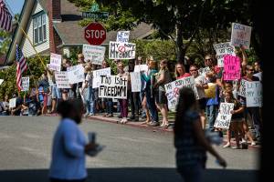 Providence employees look at anti-vaccine mandate protestors as they cross the street outside of Providence Regional Medical Center Everett on Wednesday, Aug. 18, 2021. (Olivia Vanni / The Herald)
