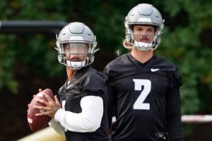 Washington State quarterback Jayden de Laura, left, looks to pass as quarterback Cammon Cooper (2) looks on during the first day of NCAA college football practice, Friday, Aug. 6, 2021, in Pullman, Wash. (AP Photo/Ted S. Warren)