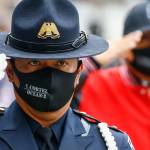 A officer salutes the symbolic remains of Officer Charlie Joe Cortez Tuesday afternoon at the Angel of the Winds Arena in Everett on August 17, 2021.  (Kevin Clark / The Herald)
