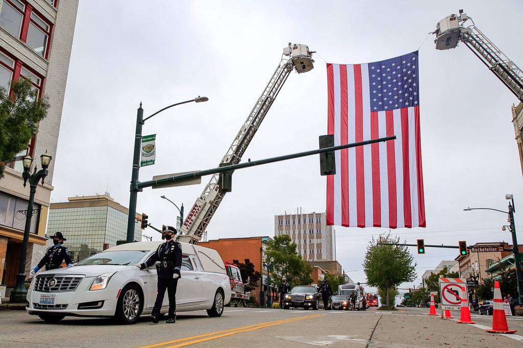 Officers escort symbolic remains of Officer Charlie Joe Cortez Tuesday afternoon at the Angel of the Winds Arena in Everett on August 17, 2021.  (Kevin Clark / The Herald)