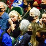 Friends and family react to the program of the memorial service for Officer Charlie Joe Cortez Tuesday afternoon at the Angel of the Winds Arena in Everett on August 17, 2021.  (Kevin Clark / The Herald)