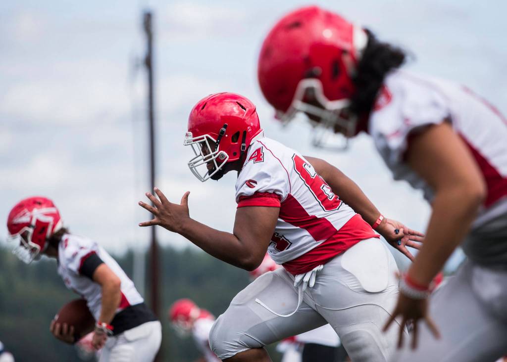Marysville Pilchucks Josiah Frank (center) warms up during football practice on Thursday in Marysville. (Olivia Vanni / The Herald)