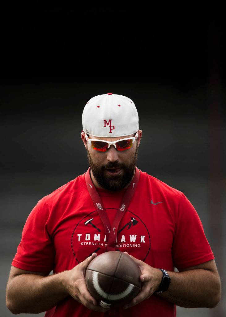A Marysville Pilchuck coach runs drills during football practice on Thursday in Marysville. (Olivia Vanni / The Herald)