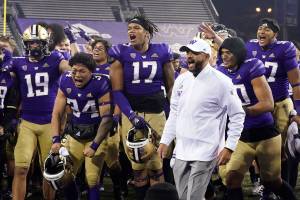 FILE - In this Nov. 28, 2020, file photo, Washington coach Jimmy Lake celebrates with his team after Washington defeated Utah 24-21 in an NCAA college football game in Seattle. Washington begins the 2021 season as one of the favorites in the Pac-12 North Division, while also trying to erase the bad taste of how last year ended when a COVID-19 outbreak brought a sudden end to an already truncated schedule. (AP Photo/Ted S. Warren, File)
