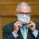 Washington Gov. Jay Inslee puts on a mask after speaking at a news conference, Wednesday, Aug. 18, 2021, at the Capitol in Olympia, Wash. Inslee announced that Washington state is expanding its vaccine mandate to include all public, charter and private school teachers and staff, as well as those working at the state's colleges and universities. The governor also expanded the statewide indoor mask mandate in place for non-vaccinated individuals to include those who are vaccinated. (AP Photo/Ted S. Warren)