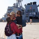 Chief Anthony Strowder kisses his wife Anika, while holding his children Idris and Naiem, after walking off the USS John Paul Jones (DDG-53), an Arleigh Burke-class guided missile destroyer, after its docks at Naval Station Everett on Monday, Aug. 23, 2021 in Everett, Washington.  The destroyer will be homeported in Everett  (Andy Bronson / The Herald)