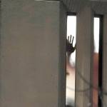 A person holds their hand up to a window inside the Pierce County Jail during a protest against police brutality passing by outside the jail, Sunday, Jan. 24, 2021, in downtown Tacoma, Wash., south of Seattle. The protest came a day after at least two people were injured when a Tacoma Police officer responding to a report of a street race drove his car through a crowd of pedestrians that had gathered around him. Several people were knocked to the ground and at least one person was run over. (AP Photo/Ted S. Warren)