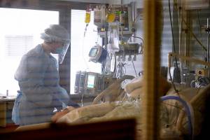 FILE - In this Jan. 26, 2021, file photo, registered nurse Andraya Zelle treats a patient in the COVID intensive care unit at UW Medical Center-Montlake in Seattle. COVID-19 hospitalizations are plunging among older Americans. The falling numbers show the country’s vaccination strategy is working, pushing deaths lower and easing pressure on the frayed hospital system. (AP Photo/Elaine Thompson, File)