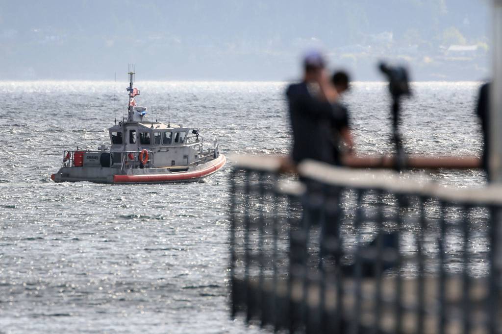 A boat patrols the area of a downed airplane in Edmonds on August 26, 2021. (Kevin Clark / The Herald)