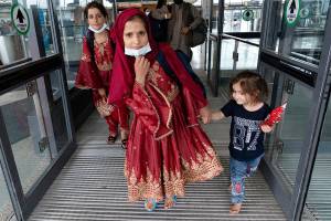 Children accompanied by their families evacuated from Kabul, Afghanistan, walk through the terminal before boarding a bus after they arrived at Washington Dulles International Airport, in Chantilly, Va., on Friday, Aug. 27, 2021. (AP Photo/Jose Luis Magana)