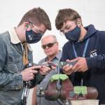 Darby ONeil (left) and Stan Ryakhovskiy practice riveting while apprentice instructor John Kraft watches. Aviation Technical Services, which repairs and overhauls passenger jets for major airlines,	offers an 18-month apprenticeship during which participants are paid to become aircraft mechanics. (Andy Bronson / The Herald)